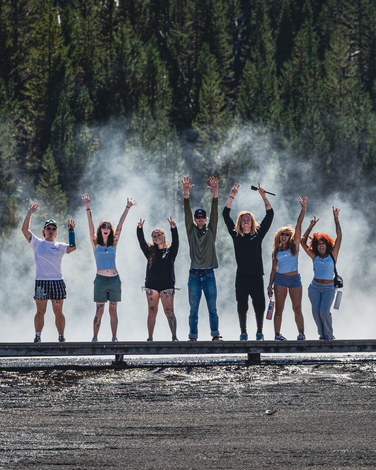 RoadTrippers celebrating together above a steaming Yellowstone spring