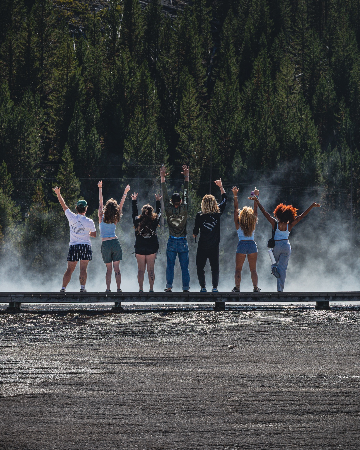 The Yellowstone RoadTrippers raising their hands above a steaming spring