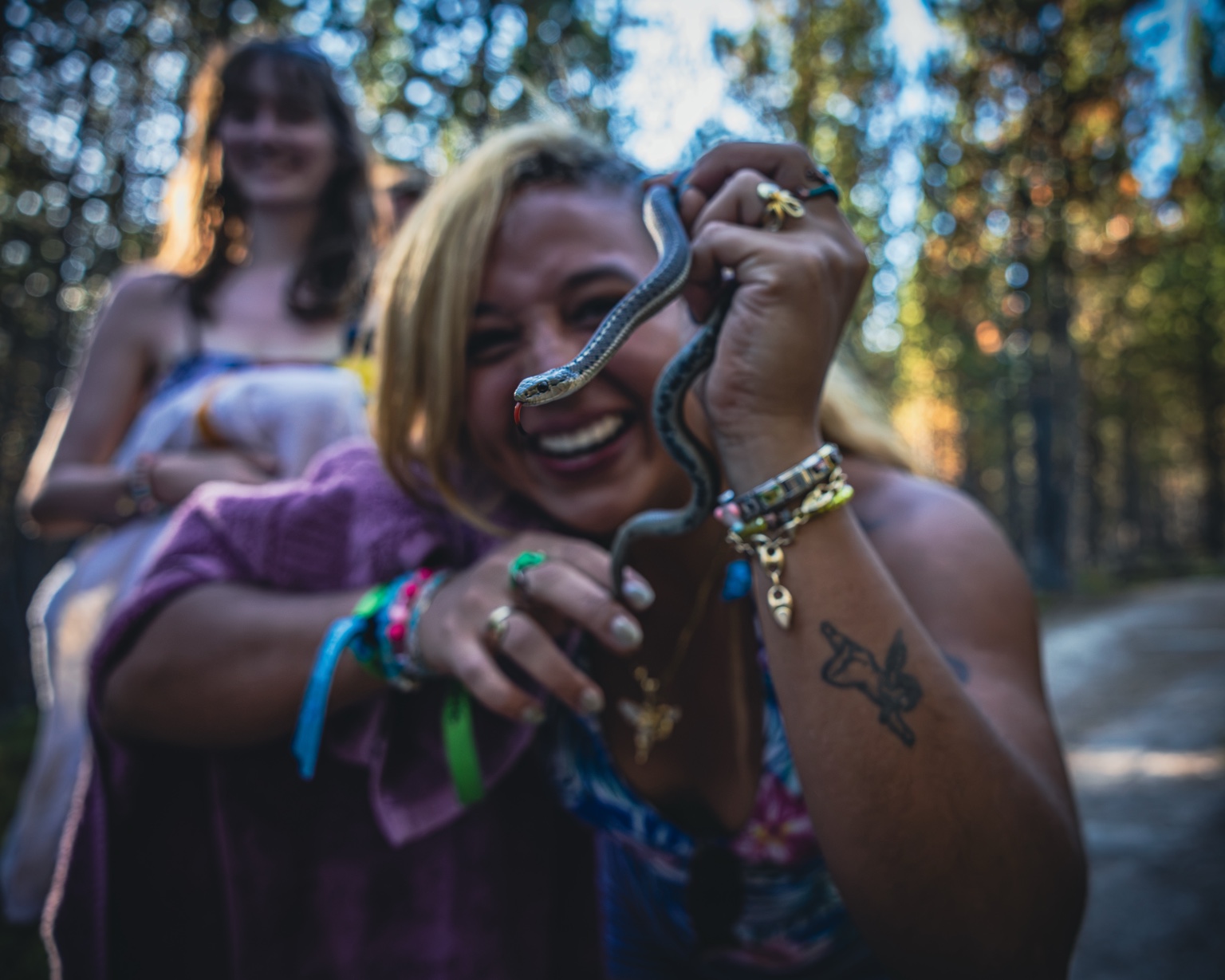 A RoadTripper smiling while holding a small snake