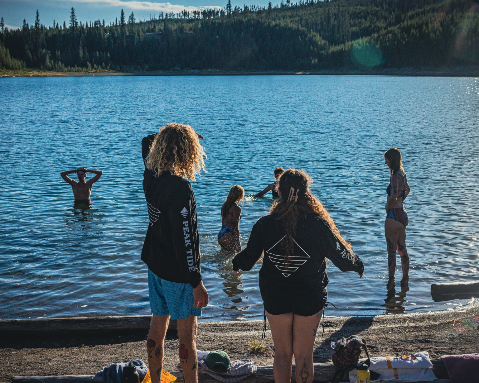 RoadTrippers wading into a blue Yellowstone lake